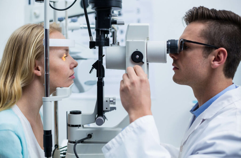 Eye doctor examining a patient’s eye with a slit lamp during an optometry appointment.